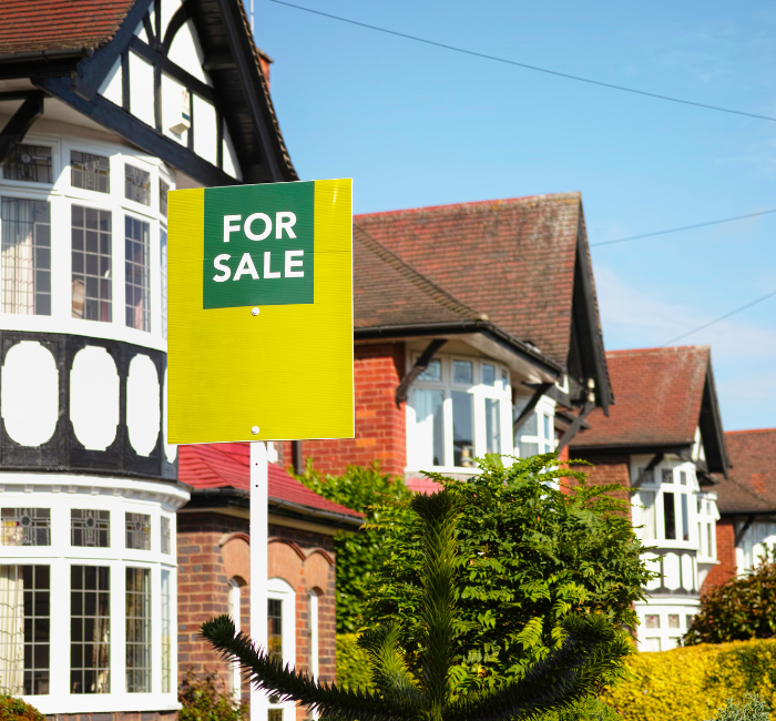 Row of Blackpool properties with a green for sale sign outside house sale